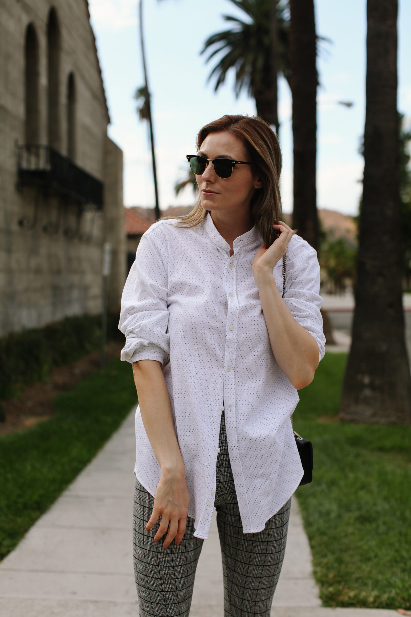 How to wear oversized button down shirt | How to Style An Oversized Button Down Shirt by popular Southern California fashion blog, Tea Cups and Tulips: image of a woman outside wearing a Zara oversized button down shirt, Banana Republic Petite Modern Sloan Skinny-Fit Washable Pant with Piping, Ray-Ban sunglasses, Happiness Boutique Circle Pendant Necklace Rose Gold, and FURLA Bella Saffiano Mini Crossbody.