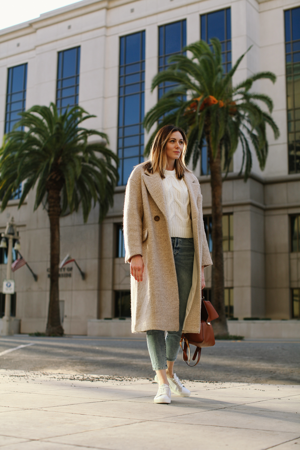 Cute Winter Coats for Women by popular LA fashion blog, Tea Cups and Tulips: image of a woman outside wearing a Zara wool winter coat, H&M Cable-knit Sweater, H&M Mom High Ankle Jeans, and Caiuma White /Ice Leather sneakers.