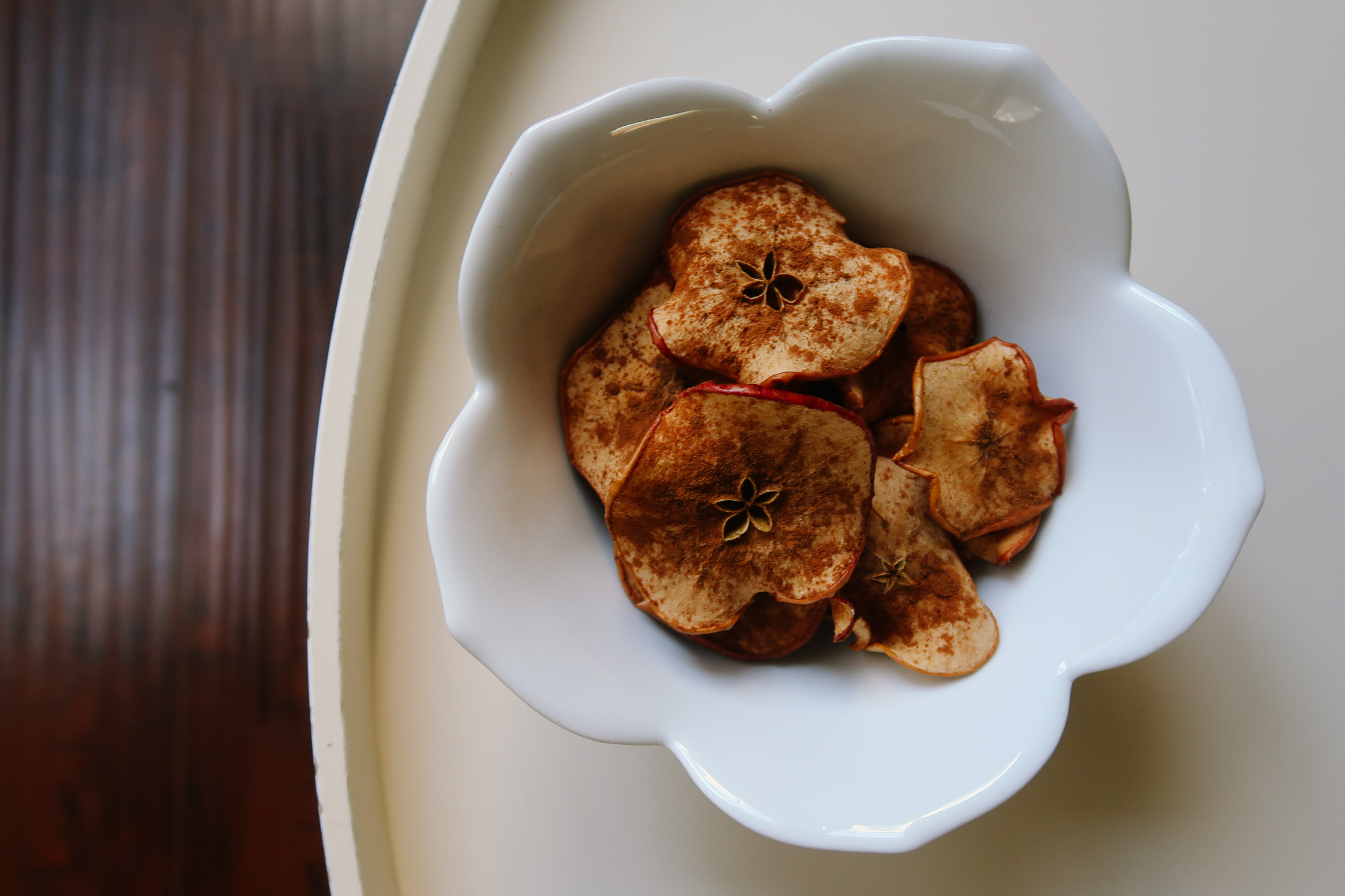 Baked Apple Chips Recipe | Baked Apple Chips by popular Los Angeles lifestyle blog, Tea Cups and Tulips: image of baked apples chips in a white ceramic bowl. 
